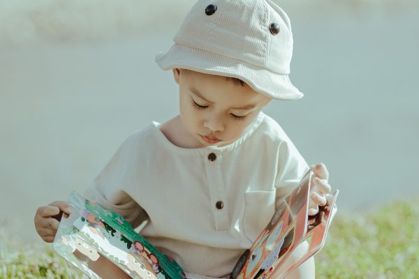 child with hat reading